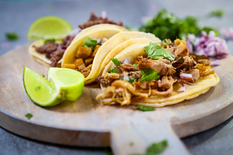 Three tacos on a wooden board